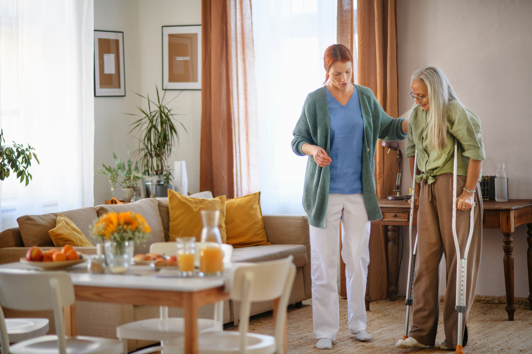 Nurse helping senior woman with walking after leg injury